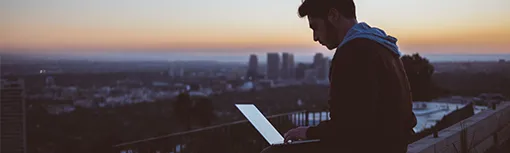 Boy on computer sending a file, with sunset below